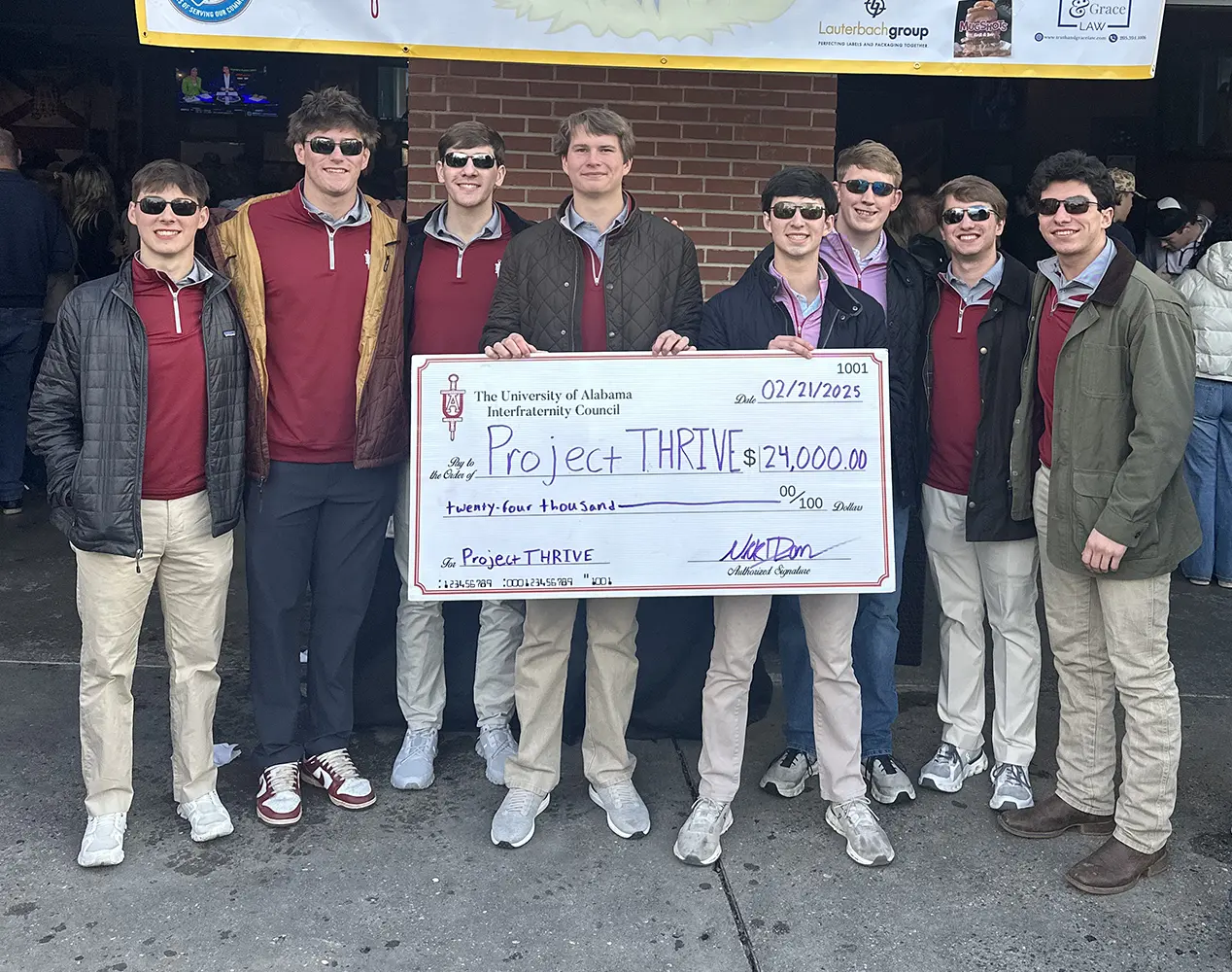 Alabama Interfraternity Council members holding a large check