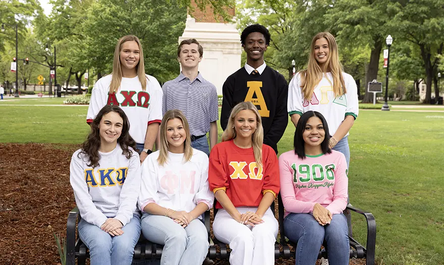 Students around a seating bench on the UA Quad